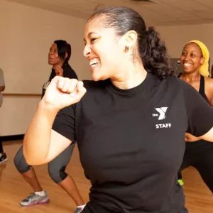 A YMCA instructor leads a group dance class.