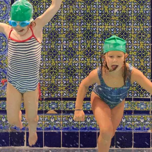 Girls jumping in pool during YMCA birthday party